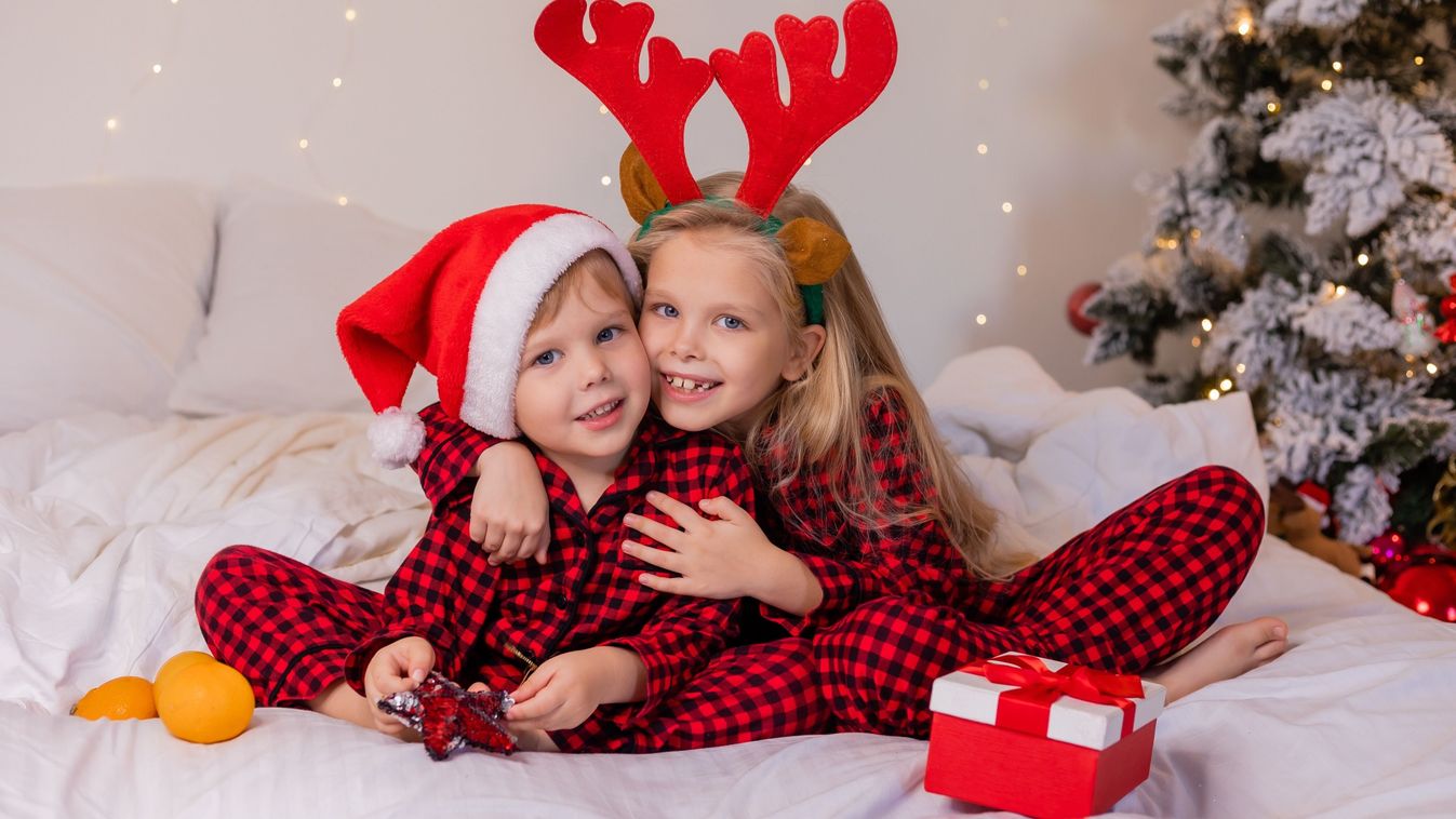 Two,Happy,Children,In,Pajamas,For,Christmas,Are,Sorting,Presents