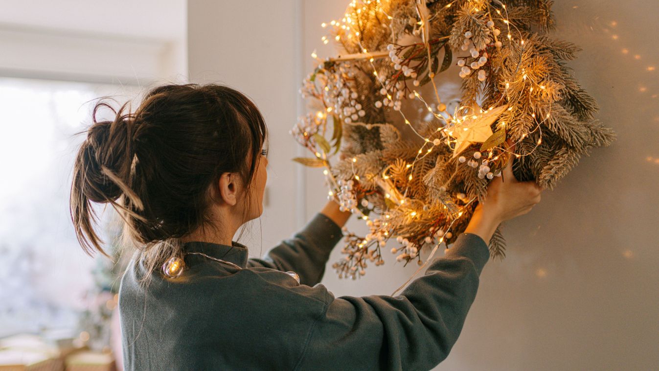 Young woman decorating her living room for the upcoming holidays