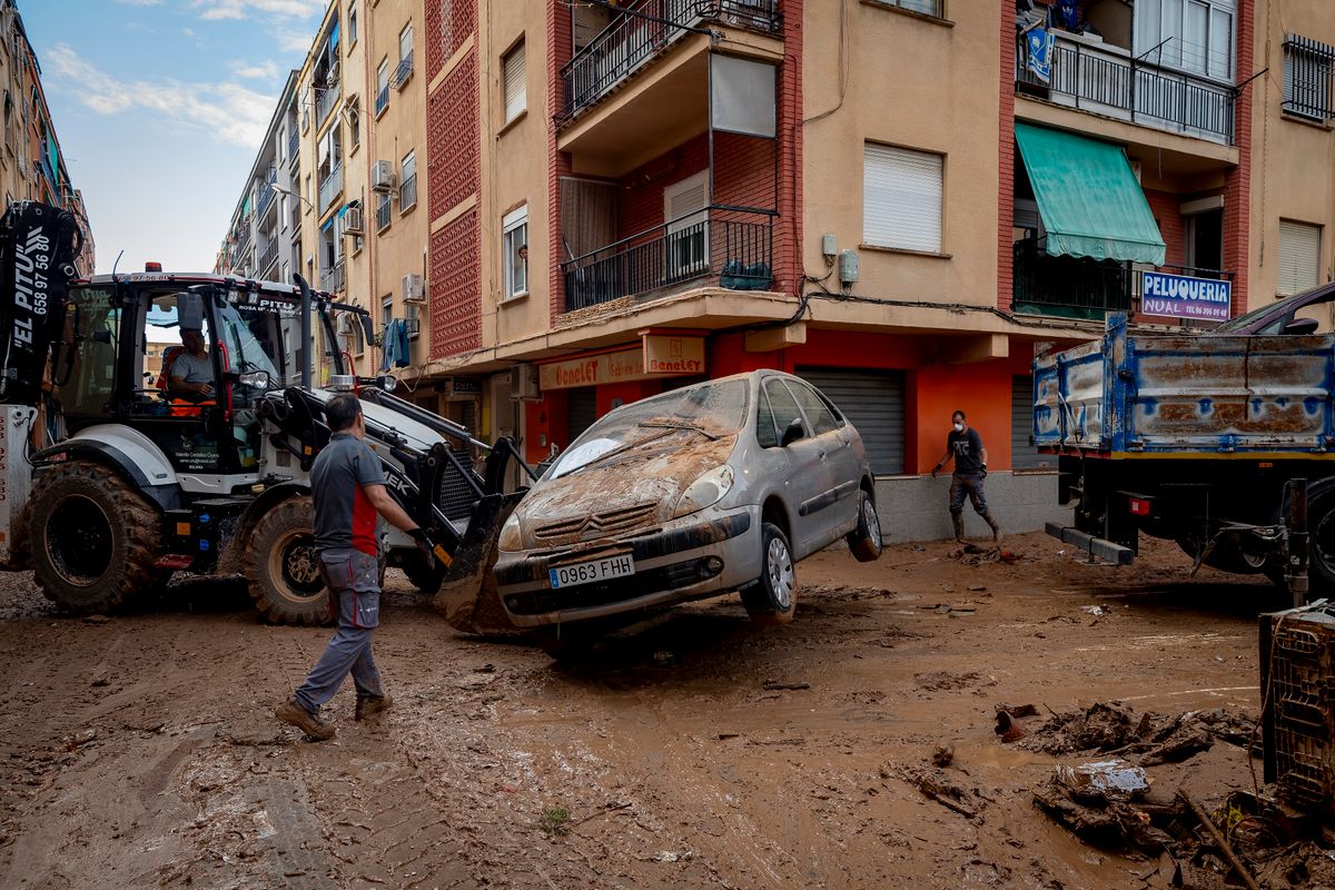 Az árvíz által elsodort autókat szállítanak el Benetússer településen, Valencia tartományban