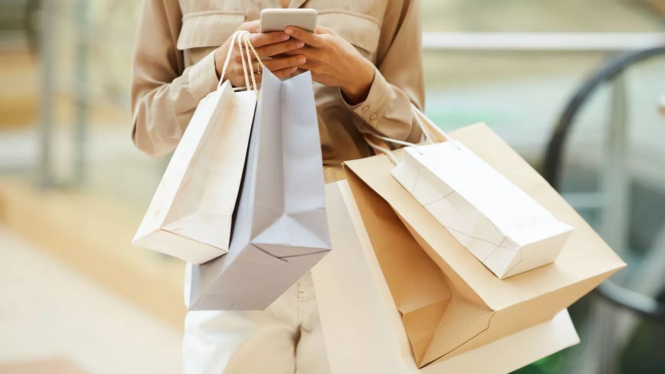 Close-up,Of,Young,Woman,Holding,Paper,Bags,And,Communicating,Online