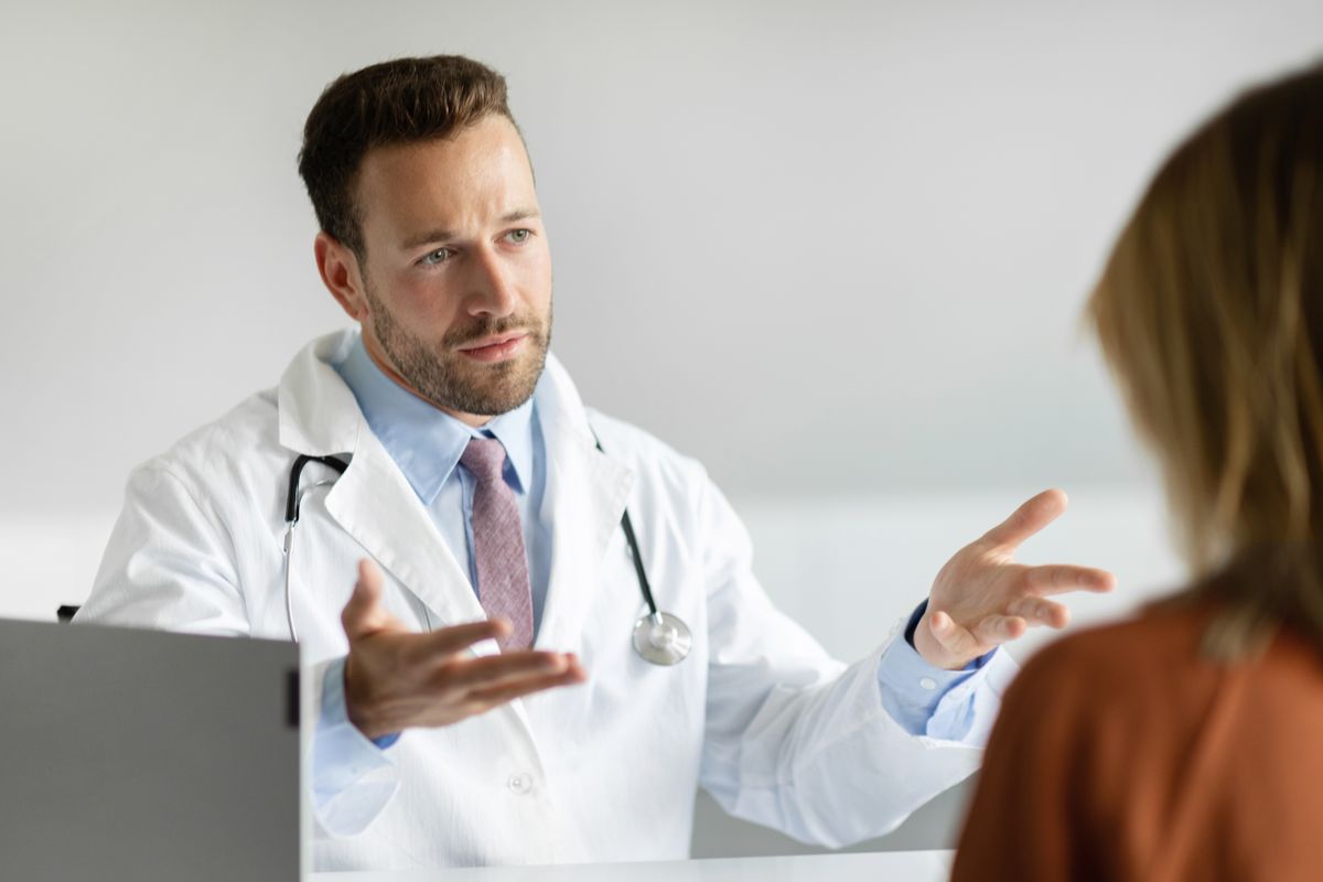 Serious,Male,Gp,Talking,With,Female,Patient,During,Meeting,In