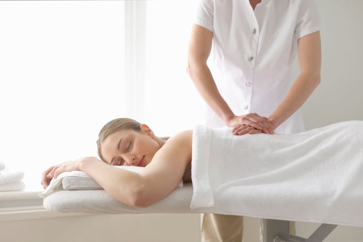 Woman being treated by masseuse.