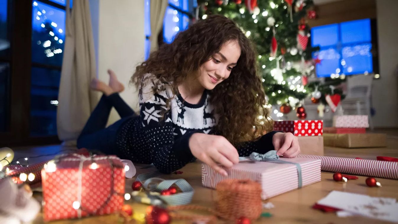 Woman,Lying,In,The,Middle,Of,Wrapped,Christmas,Presents,By