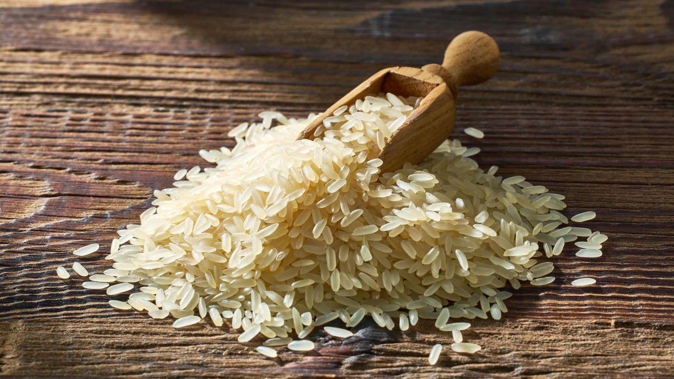 Pile,Of,Raw,Rice,On,Sunny,Wooden,Kitchen,Table,,Ready