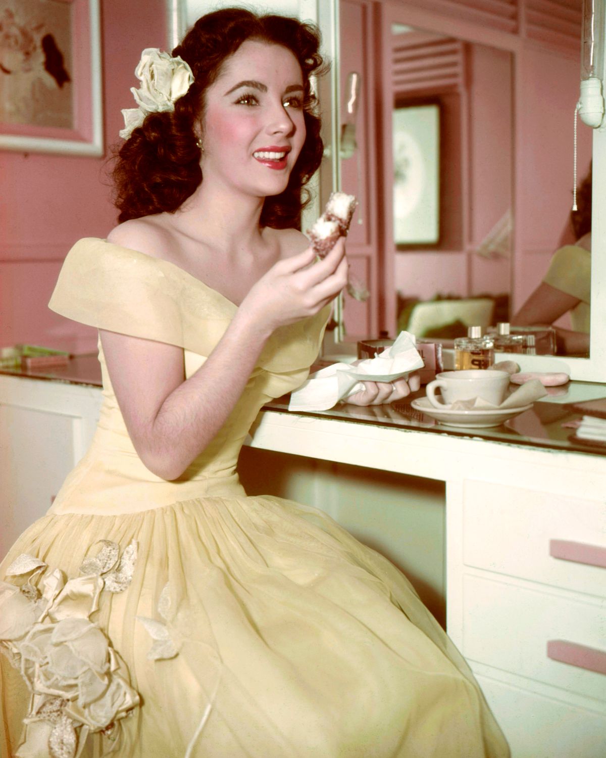 Actress Elizabeth Taylor enjoys tea and a cake in her dressing room, circa 1950. (Photo by Silver Screen Collection/Getty Images)