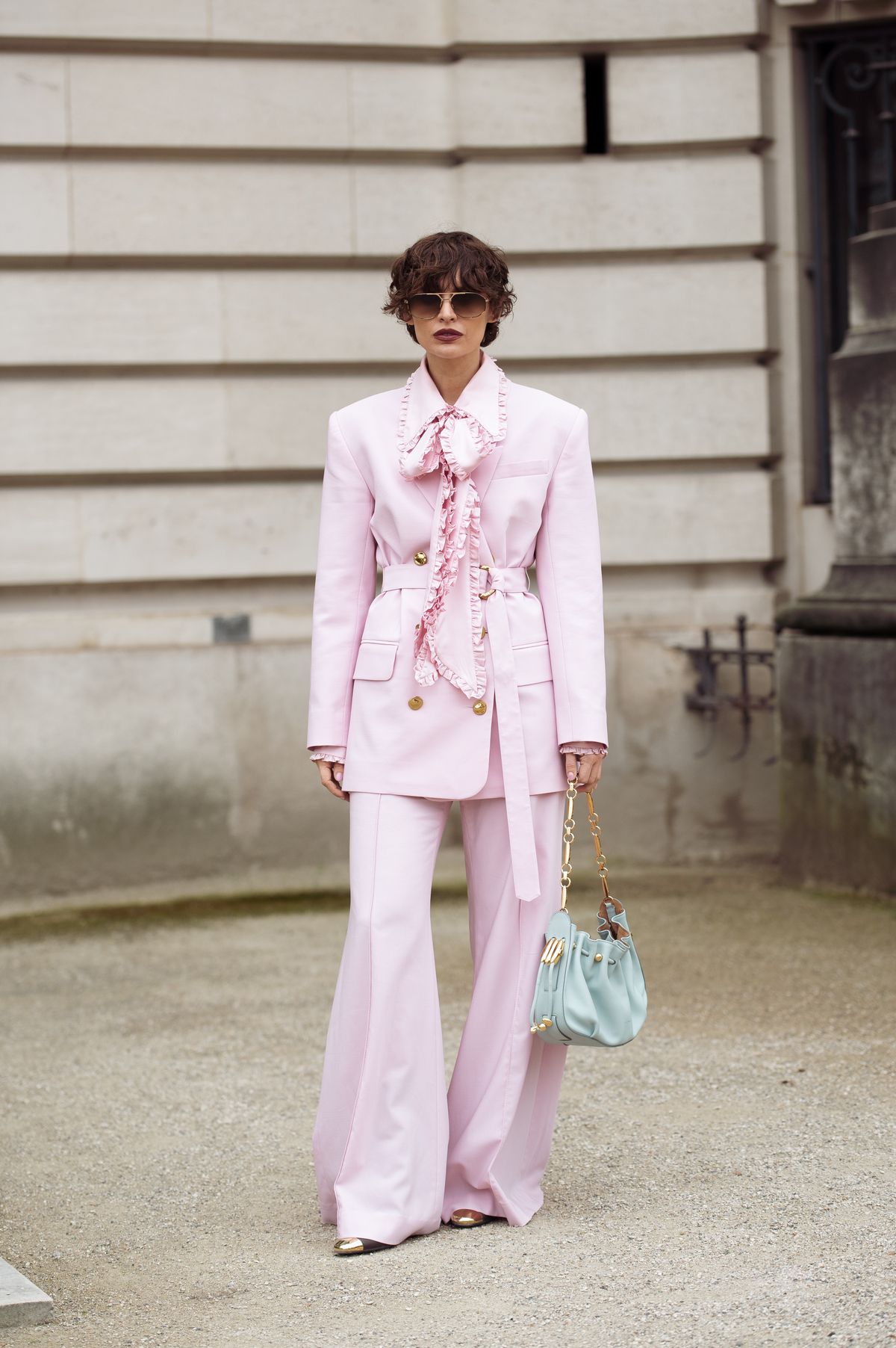 PARIS, FRANCE - MARCH 10: Irina Kro Eicke wears pink suit, wide pants and blazer with a belt and bow tie and mint green bag outside the Zimmermann fashion show during the Womenswear Fall/Winter 2025/2026 as part of Paris Fashion Week on March 10, 2025 in Paris, France. (Photo by Raimonda Kulikauskiene/Getty Images)