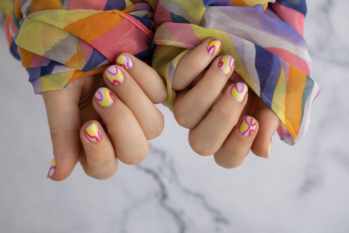 Pastel softness colorful manicured nails. Woman showing her new summer manicure in colors of pastel palette. Simplicity decor fresh spring vibes earth-colored neutral tones