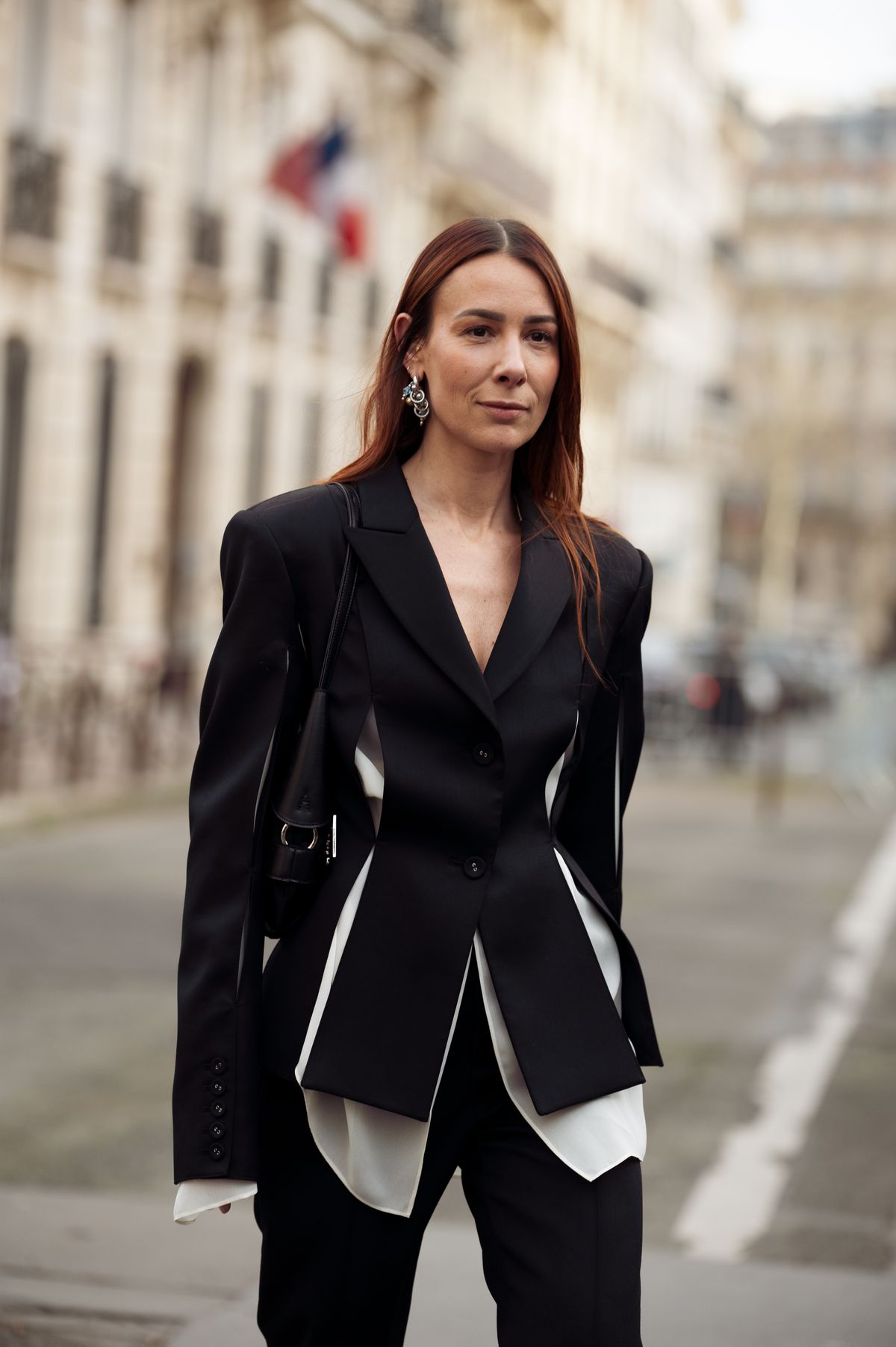 PARIS, FRANCE - MARCH 10: Alice Barbier wears a black and white blazer with cut-out details, a black leather bag, black trousers outside Rokh fashion show during the Womenswear Fall/Winter 2025/2026 as part of Paris Fashion Week on March 10, 2025 in Paris, France. (Photo by Raimonda Kulikauskiene/Getty Images)