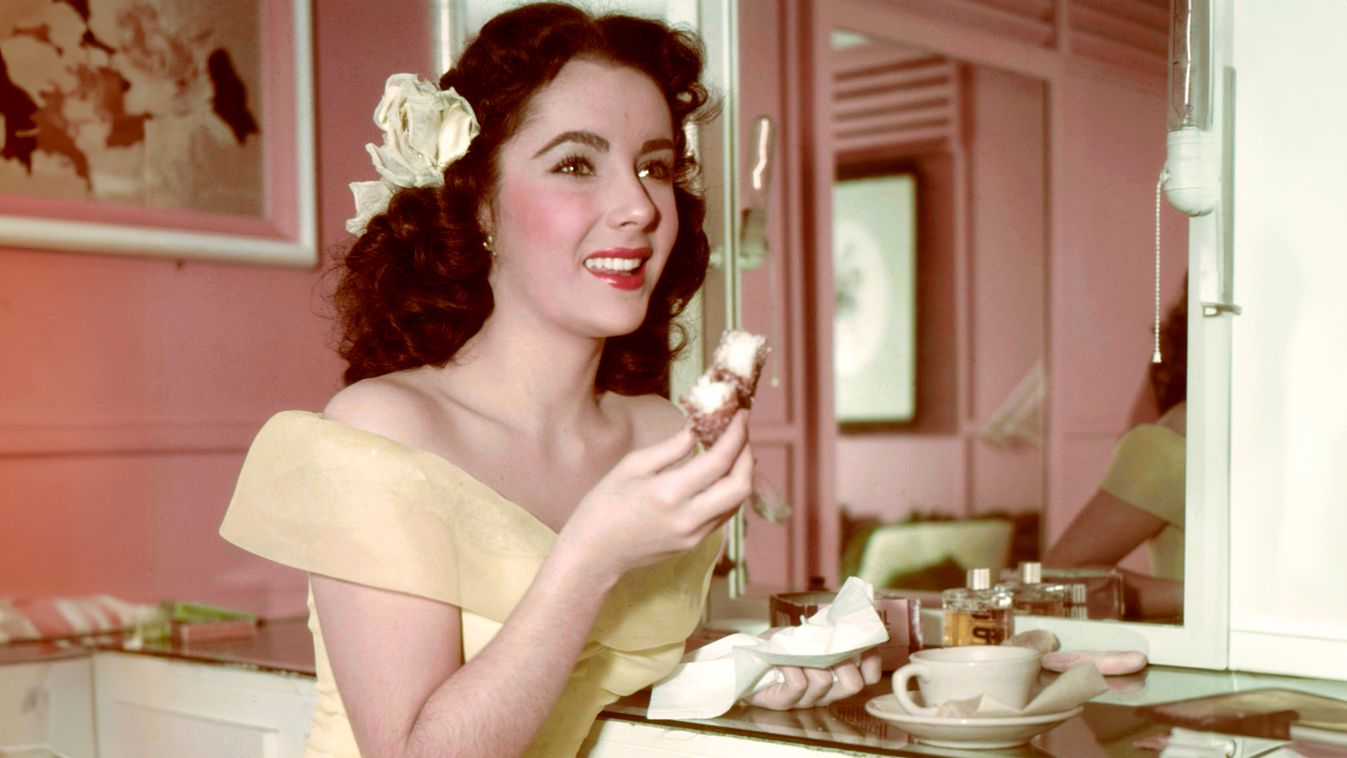 Actress Elizabeth Taylor enjoys tea and a cake in her dressing room, circa 1950. (Photo by Silver Screen Collection/Getty Images)