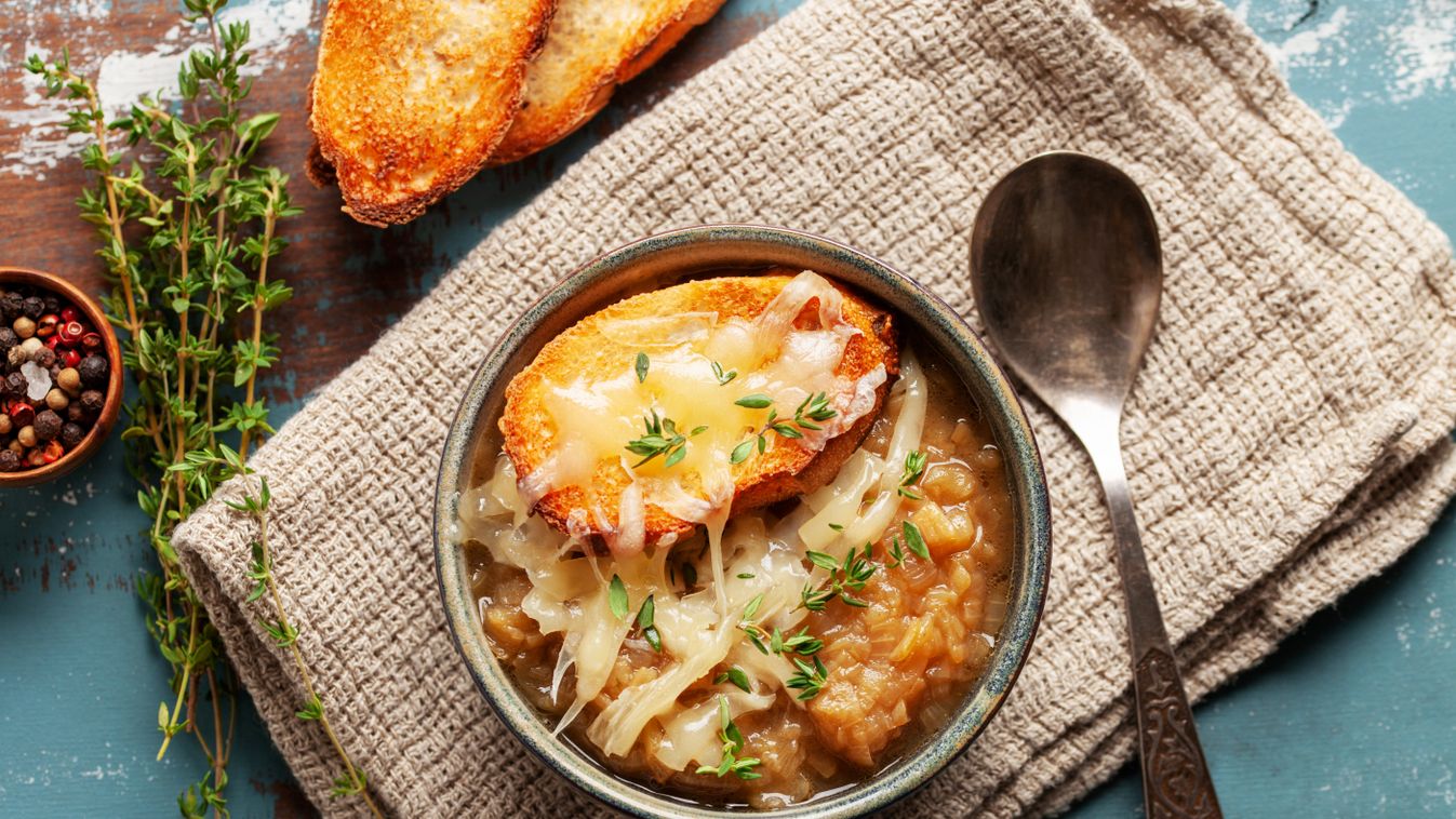 Classic French onion soup baked with cheese croutons sprinkled with fresh thyme. Top view