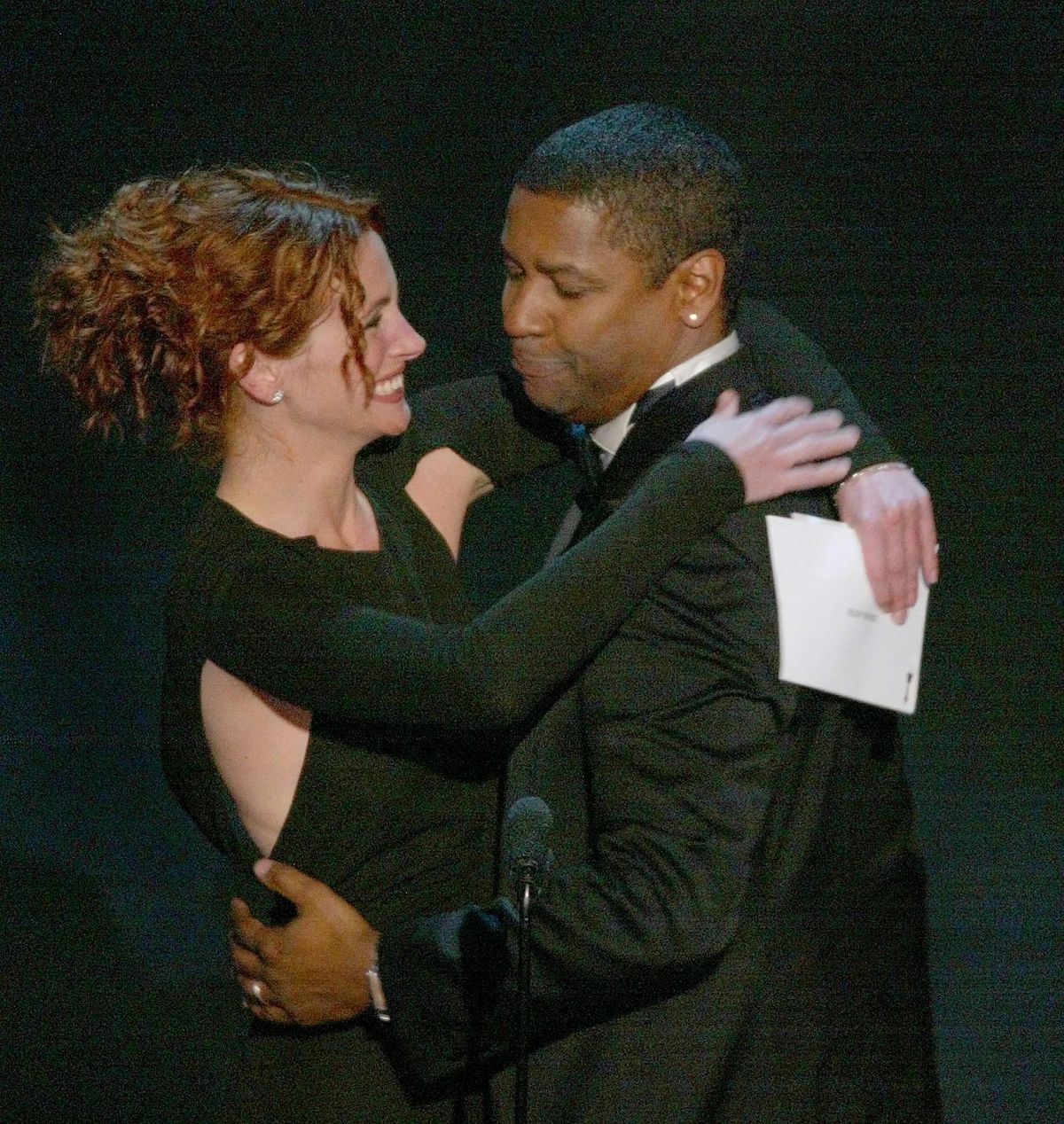 US actor Denzel Washington (R) is congratulated by presenter Julia Roberts as he accepts his Oscar for best performance by an actor in a leading role for "Training Day" during the 74th Academy Awards at the Kodak Theater in Hollywood, 24 March 2002.   AFP PHOTO/TIMOTHY A. CLARY (Photo by TIMOTHY A. CLARY / AFP)