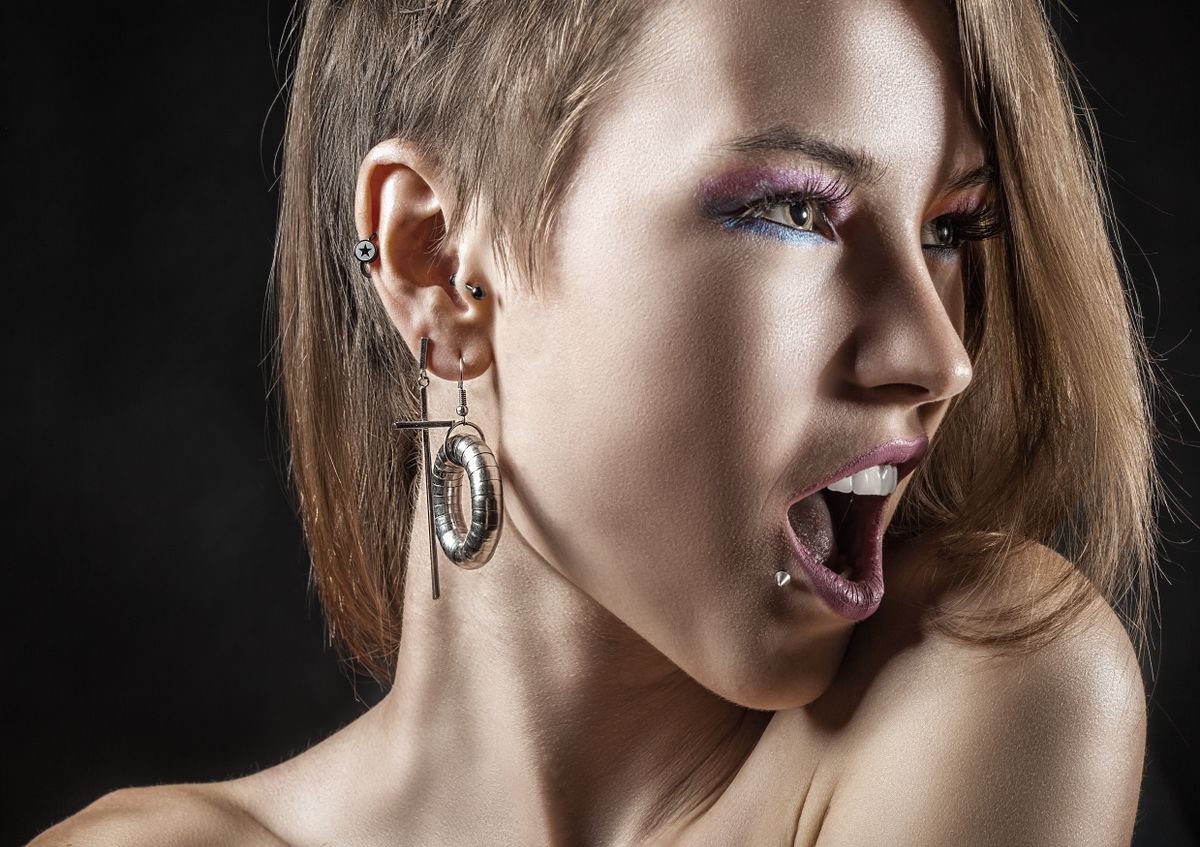 Portrait of a sexy girl with piercings on a black background