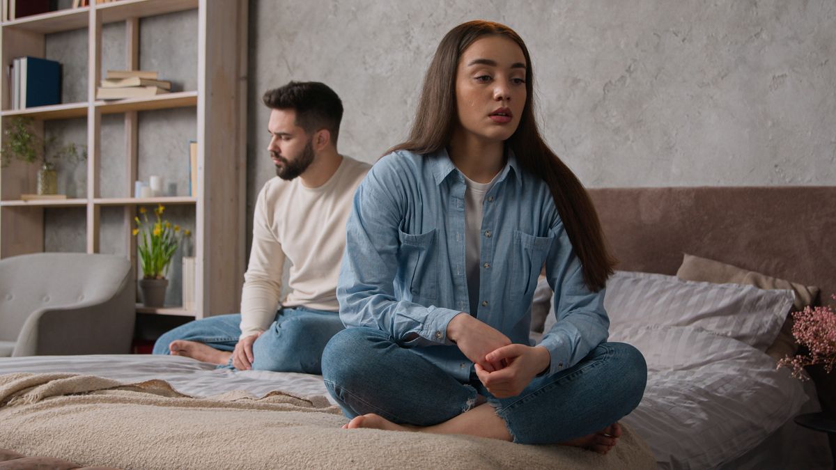 Offended upset woman girlfriend offense to boyfriend marriage problem family quarrel in bedroom Caucasian sad couple sit separately on bed after conflict relationship breakup guilty man try to apology