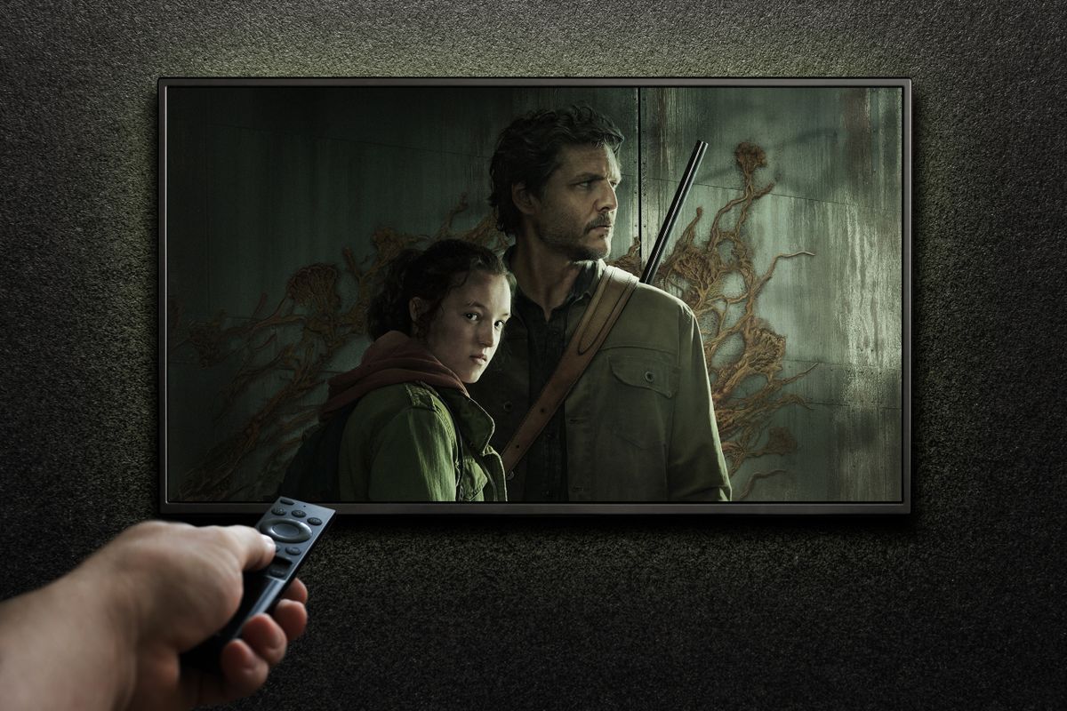 TV screen playing The Last of Us trailer or movie. Man turns on TV with remote control. Moscow, Russia - January 11, 2023.