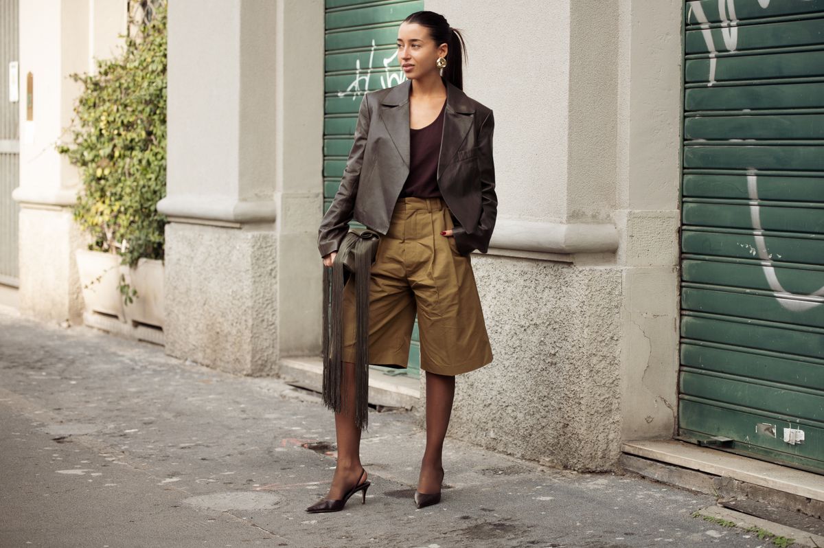MILAN, ITALY - FEBRUARY 26: Maria Monfort Matutes wears khaki shorts, black tights, dark brown top, brown leather jacket and green bag with tassels outside the Vivetta fashion show during the Milan Fashion Week Womenswear Fall/Winter 2025/2026 on February 26, 2025 in Milan, Italy. (Photo by Raimonda Kulikauskiene/Getty Images)