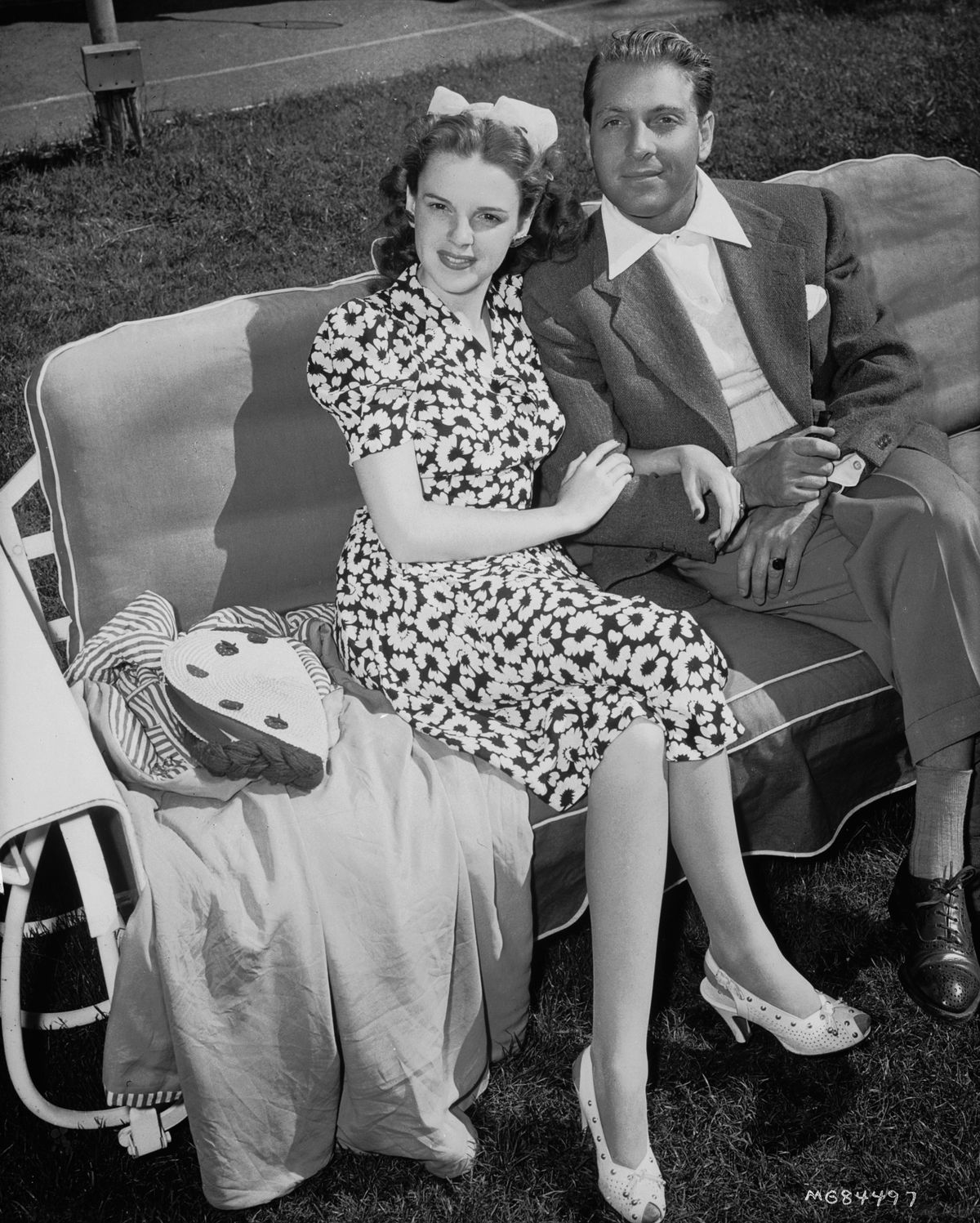 1941:  Young bride with a bow in her hair, Judy Garland (Frances Ethel Gumm) (1922 - 1969) sits on a garden lounger holding the arm of her first husband, bandleader David Rose.  (Arról sem lehetett szabad akaratuk, hogy kivel házasodtak össze