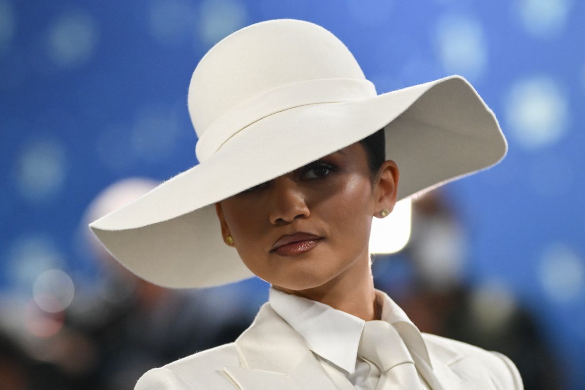 Zendaya egy Pharrell Williams által tervezett fehér, testhezálló, háromrészes, egyedi Louis Vuitton öltönyben