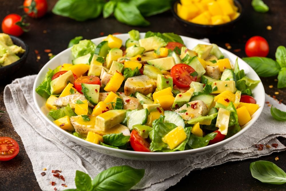 Tasty Chicken mango salad with avocado, cucumber, cherry tomatoes. Healthy food