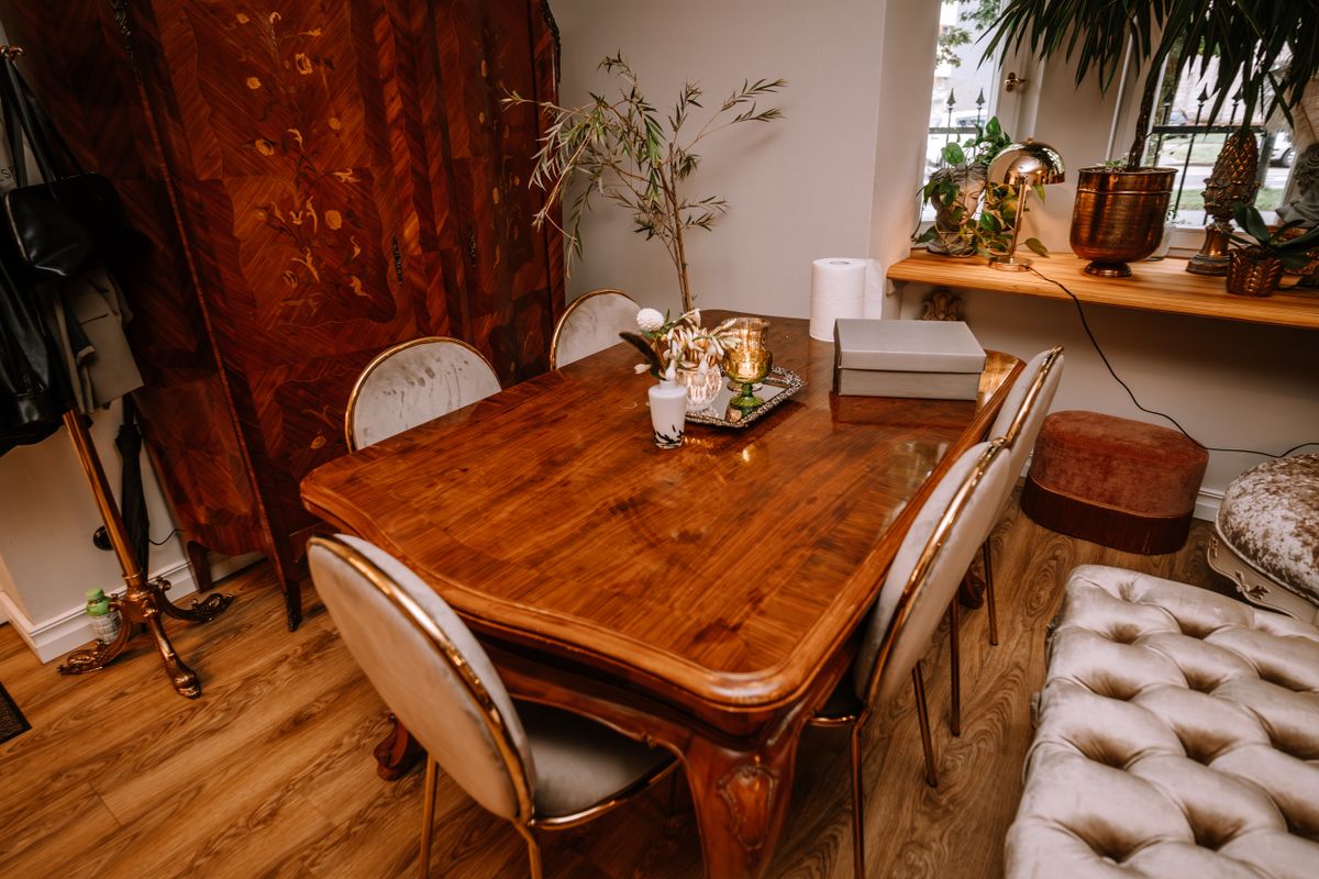 Riga, Latvia, - August 26, 2023 - A cozy dining room with a polished wooden table, elegant chairs, decorative items, and plants, creating a warm and inviting atmosphere.