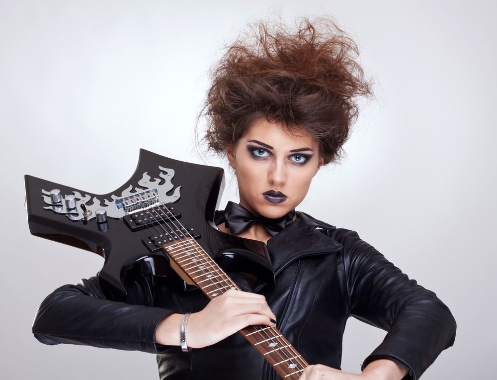 attractive woman guitarist holding her guitar on shoulder