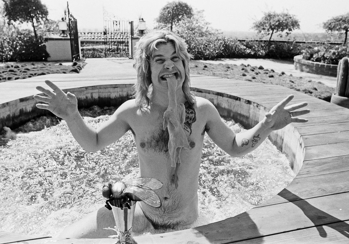 Ozzy Osbourne, former lead singer of Black Sabbath, pictured in his open air hot tub in the garden of his luxury home in Goldwater Canyon, Beverly Hills,California biting the head of a rubber chicken. 28th April 1982.(Photo by Eddie Sanderson/Getty Images).