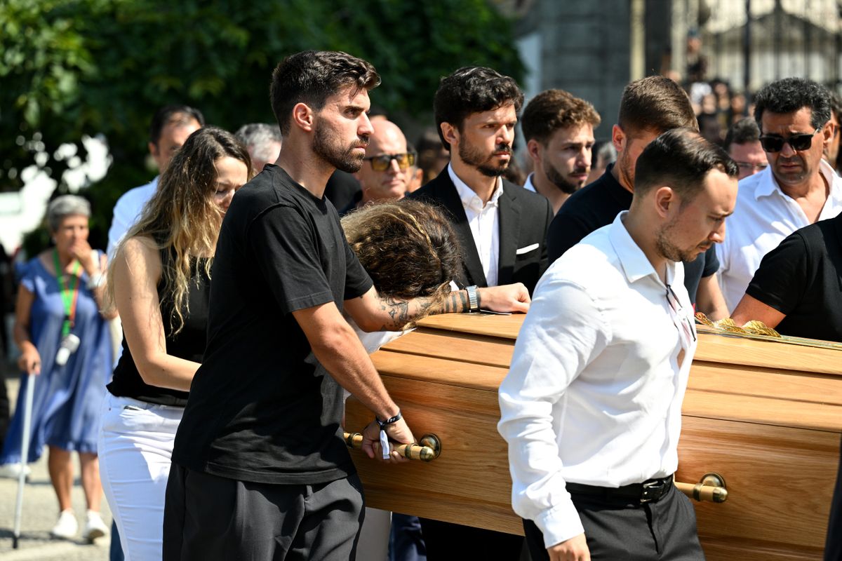 GONDOMAR, PORTUGAL - JULY 05: Rute Cardoso, Wife of Diogo Jota, leans on the arm of Ruben Neves, football player for Alhilal Saudi Club and the Portugal national team, as the coffin of Diogo Jota is carried out of the Church after a funeral held for Diogo Jota and his brother Andre Silva at Igreja Matriz de Gondomar on July 05, 2025 in Gondomar, Portugal. Diogo Jota was a professional football player for Liverpool FC and the Portuguese national team, while Andre Silva played for FC Penafiel in Portugal's second tier. The brothers died in a car accident in the province of Zamora, Spain, on July 3. (Photo by Octavio Passos/Getty Images)