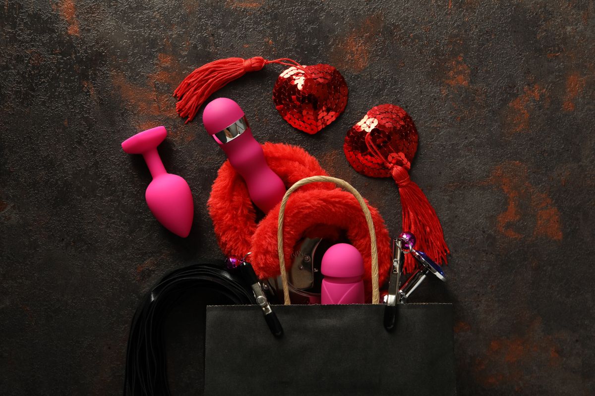 Sex toys spill out of a paper bag, top view