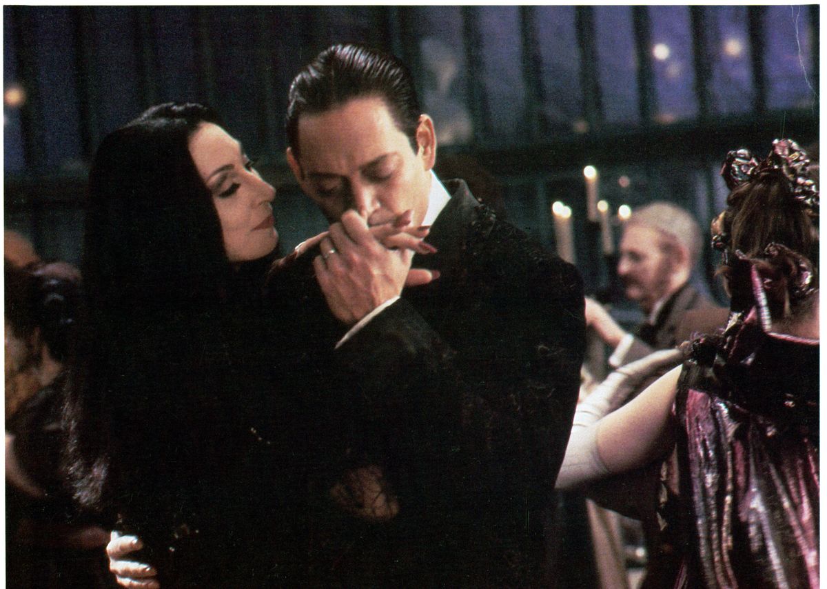 Anjelica Huston is kissed by Raul Julia in a scene from the film 'The Addams Family', 1991. (Photo by Orion/Getty Images)
