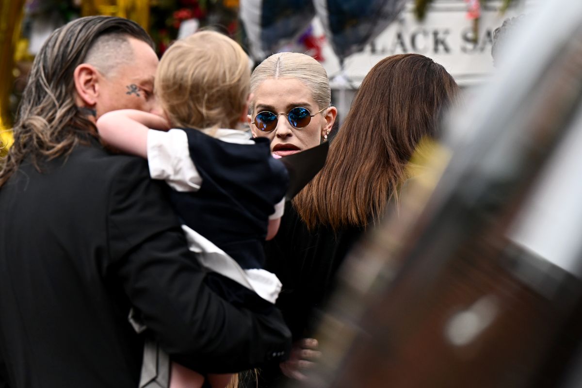 BIRMINGHAM, ENGLAND - JULY 30: Sid Wilson (L), Kelly Osbourne (C) and their son Sidney Wilson (2nd L) arrive to view tributes to the late Ozzy Osbourne from fans as his funeral cortege travels through his home city of Birmingham on July 30, 2025 in Birmingham, England. The Black Sabbath frontman passed away on July 22nd at the age of 76. His death occurred just a little over two weeks after his final live performance at the 'Back to the Beginning' concert in his hometown of Birmingham. (Photo by Leon Neal/Getty Images)