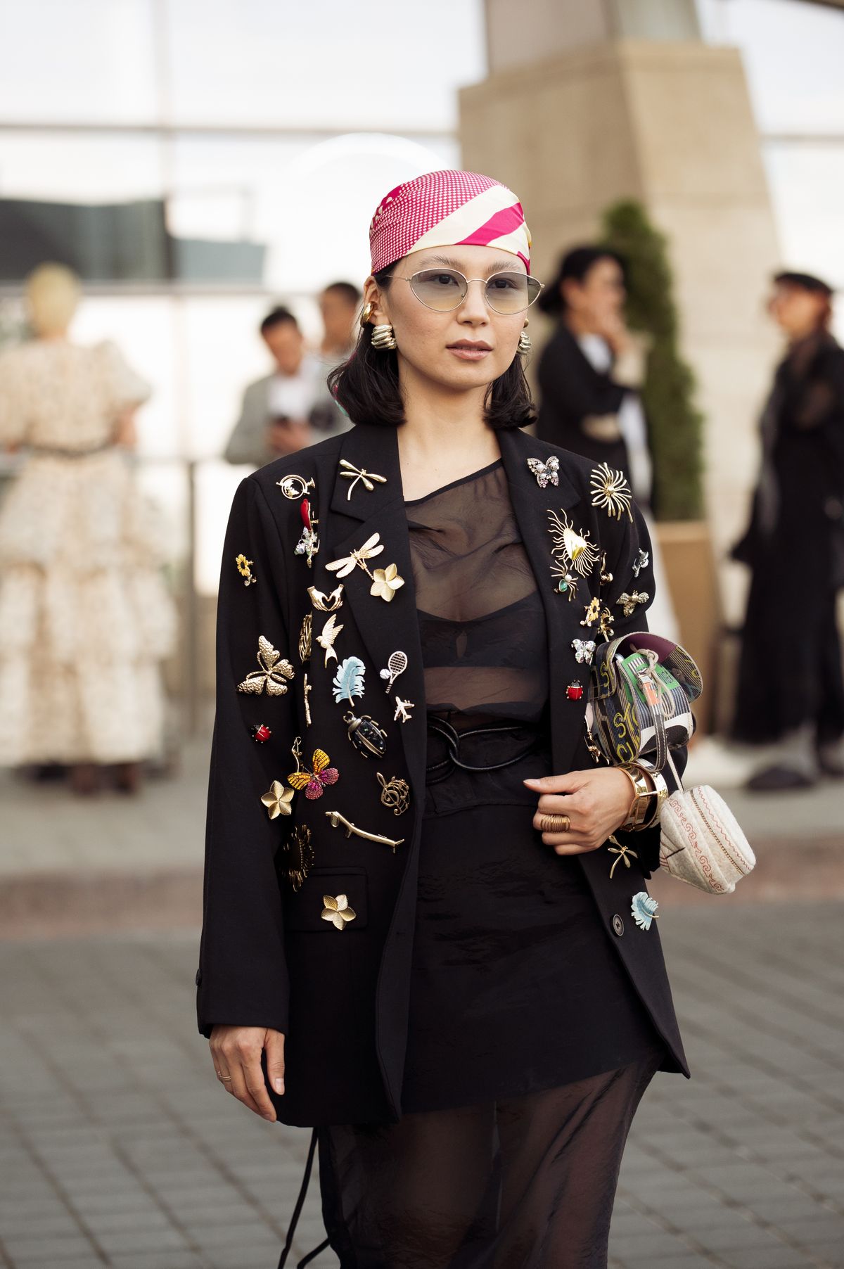 ALMATY, KAZAKHSTAN - MAY 05: A guest wears black sheer dress, black oversized blazer with metal pins and pink and white head scarf during day 3 of Visa Fashion Week Almaty 2025 on May 05, 2025 in Almaty, Kazakhstan. (Photo by Raimonda Kulikauskiene/Getty Images)