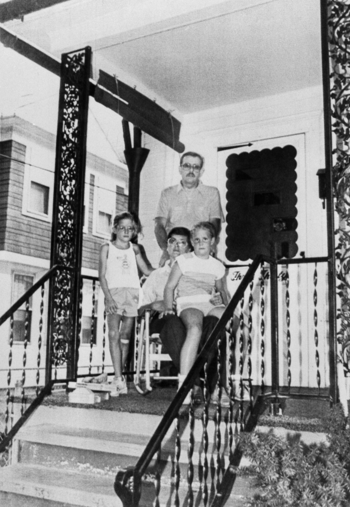Janet and Jack Smurl are shown with their twin daughters Carin and Shannon on front porch of their Chase Street home. The family claims is the house is haunted.  After two unsuccessful attempts to drive the demons from their home, the family is asking the Roman Catholic Diocese of Scranton fro help.  (Photo by Bettmann Archive/Getty Images)