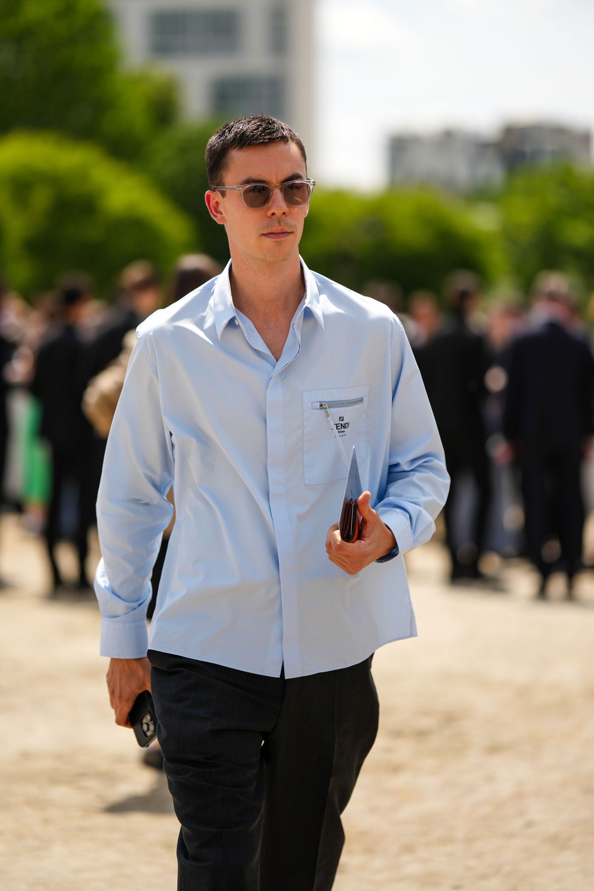 PARIS, FRANCE - JUNE 23: A guest wears black circle sunglasses, a pale blue with embroidered black pattern shirt from Fendi, black suit pants, outside Dior, during the Menswear Spring/Summer 2024 as part of  Paris Fashion Week on June 23, 2023 in Paris, France. (Photo by Edward Berthelot/Getty Images)