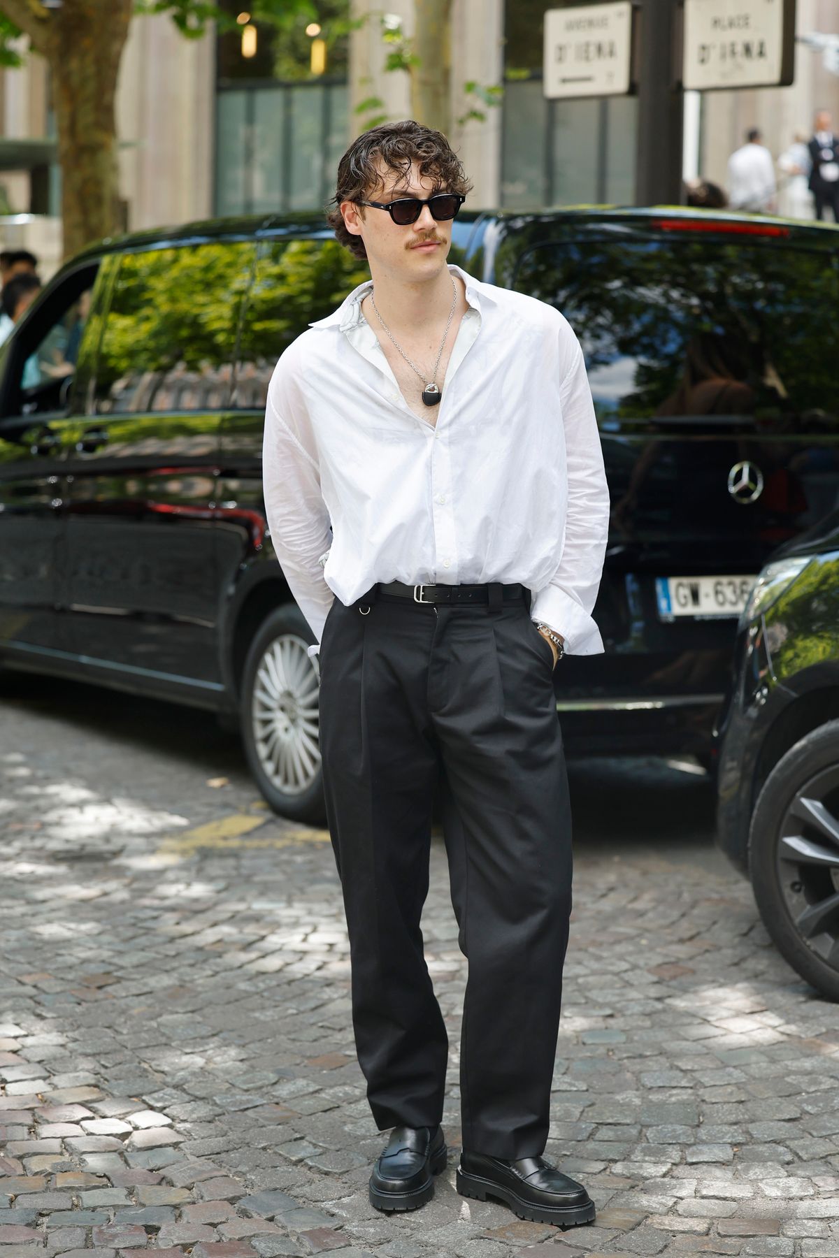 PARIS, FRANCE - JUNE 28: A guest wears white shirt, black trousers, black loafers, outside Hermes, during the Menswear Spring/Summer 2026 show as part of Paris Fashion Week on June 28, 2025 in Paris, France. (Photo by Claudio Lavenia/Getty Images)