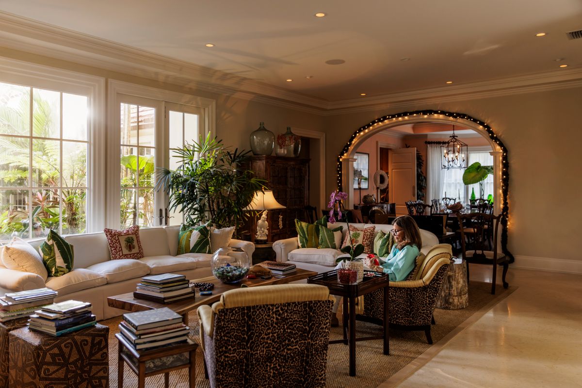 Relaxed senior woman reading a text message on her smart phone as she relaxes in her elegant living room at home