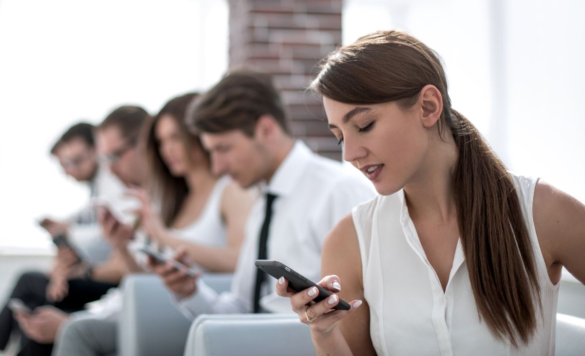 young employee looking at text message on smartphone