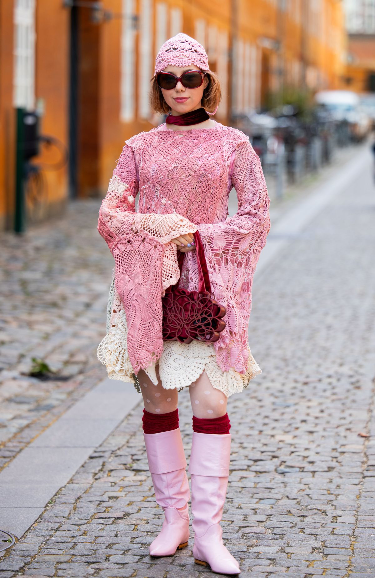 COPENHAGEN, DENMARK - AUGUST 05: A guest wears pink laced dress, head piece, red bag outside Anne Sofie Madsen during Copenhagen Fashion Week day two on August 05, 2025 in Copenhagen, Denmark. (Photo by Christian Vierig/Getty Images)