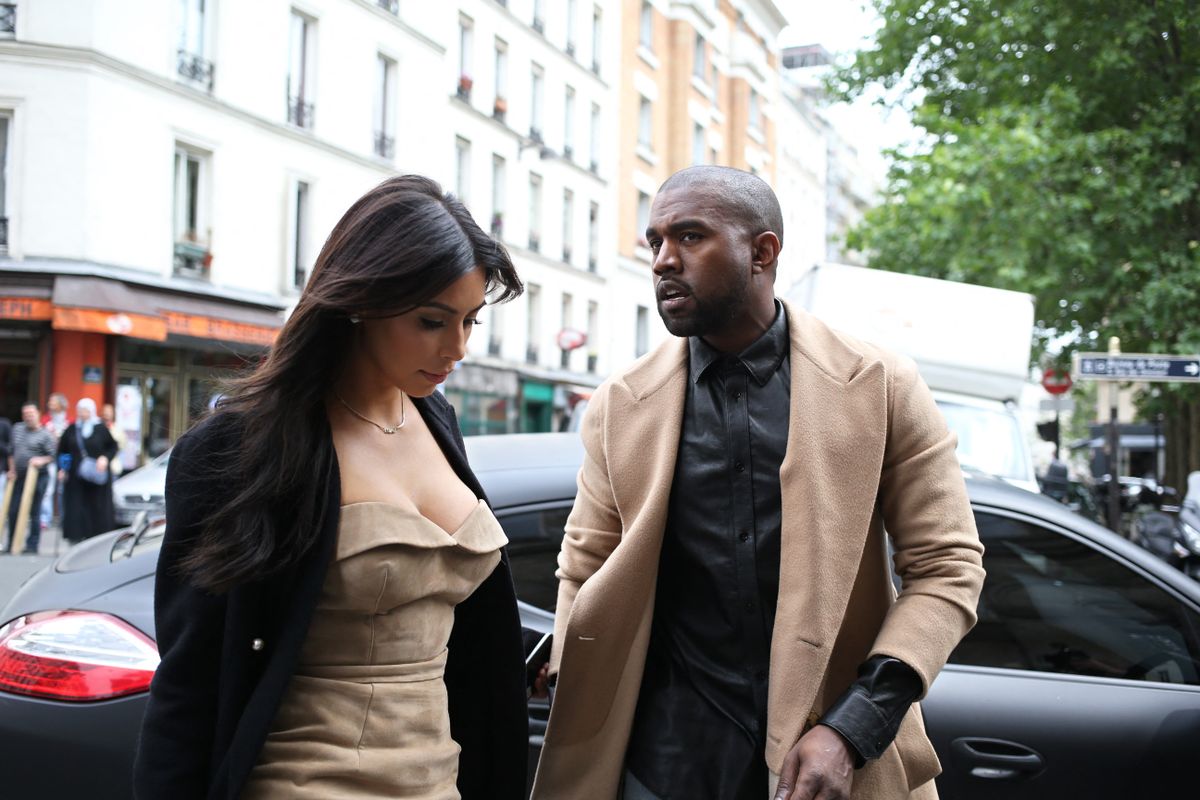 Kanye West and Kim Kardashian stroll through rue Darboy in the 11th district near Belleville as they shop on May 21, 2014 in Paris. The celebrity pair is expected to be tying the knot this weekend, fuelling speculation about the wedding's location. Florence's La Nazione daily reported that they would have a marriage ceremony in France early on May 24, before travelling to Italy for the party. AFP PHOTO / KENZO TRIBOUILLARD (Photo by KENZO TRIBOUILLARD / AFP)