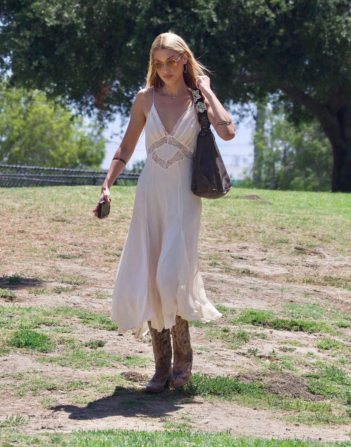 *EXCLUSIVE* Los Angeles, CA    Bella Hadid was spotted with a large group of pals as they celebrated a baby shower at a park in Los Angeles. She shared a big hug as she greeted a pal before enduldging in some of the food that was prepared for the party. Bella wore her signature cowboy boots, along with a summery white dress. She carried a brown Valentino bag over her shoulder as she made her way home after a couple hours.

*UK Clients - Pictures Containing Children
Please Pixelate Face Prior To Publication*,Image: 1026504029, License: Rights-managed, Restrictions: , Model Release: no, Pictured: Bella Hadid