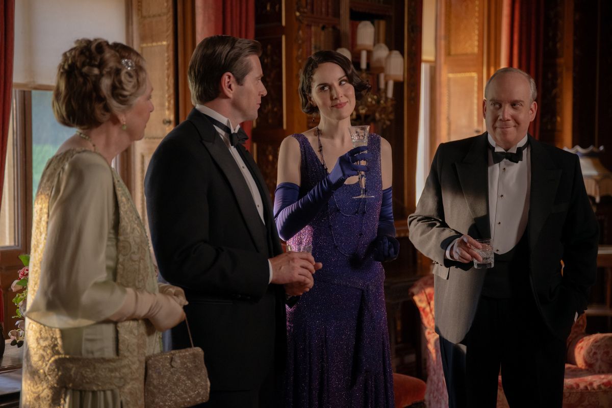 L to R) Penelope Wilton stars as Isobel Merton, Allen Leech as Tom Branson, Michelle Dockery as Lady Mary and Paul Giamatti as Harold Levinson in DOWNTON ABBEY: The Grand Finale, a Focus Features release.