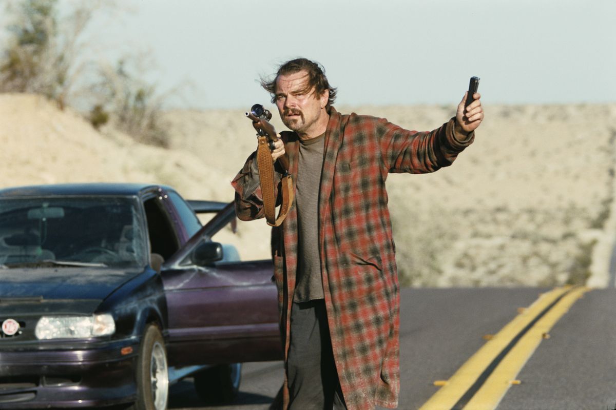 Leonardo DiCaprio pizsamában, fegyverrel a kezében. 