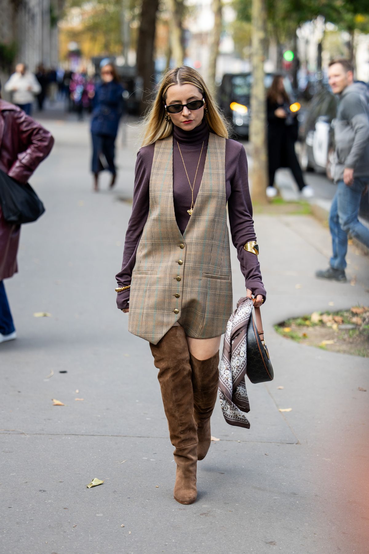 PARIS, FRANCE - SEPTEMBER 30: Julia Comil wears checkered vest dress, turtleneck, bracelet, brown suede boots outside Zimmermann during Womenswear Spring/Summer 2025 as part of  Paris Fashion Week on September 30, 2024 in Paris, France. (Photo by Christian Vierig/Getty Images)