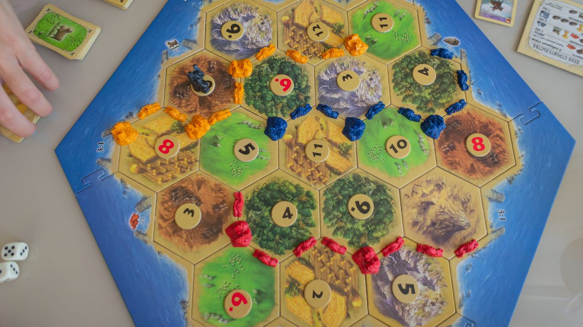Close up top view flat lay of the popular strategic economic board game Settlers of Catan. Concept: entertainment in the family and with friends, hobbies, free time, weekends