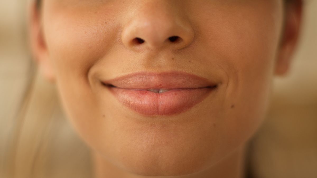 Close up face lips of unrecognizable Indian Arabian woman girl female lady smiling smile sensuality plastic surgery beauty lipstick make up health medicine cropped view indoors feminine cosmetology