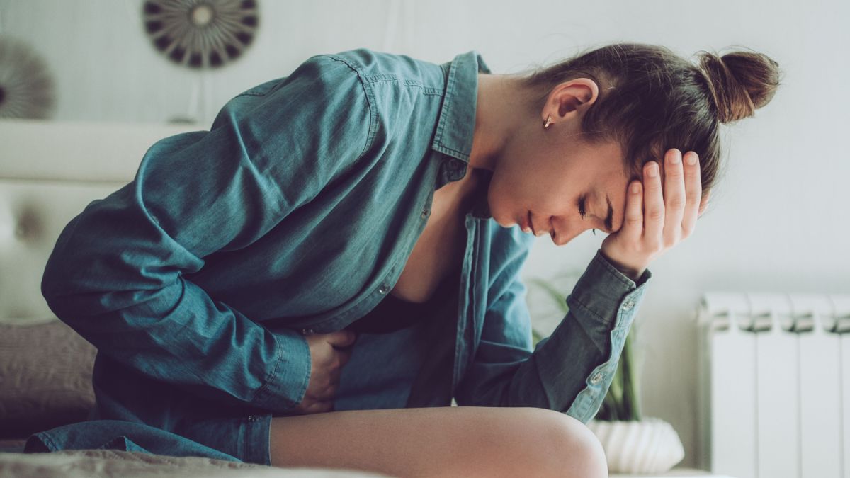 Méhpolippal küzdő nő ül az ágyon.