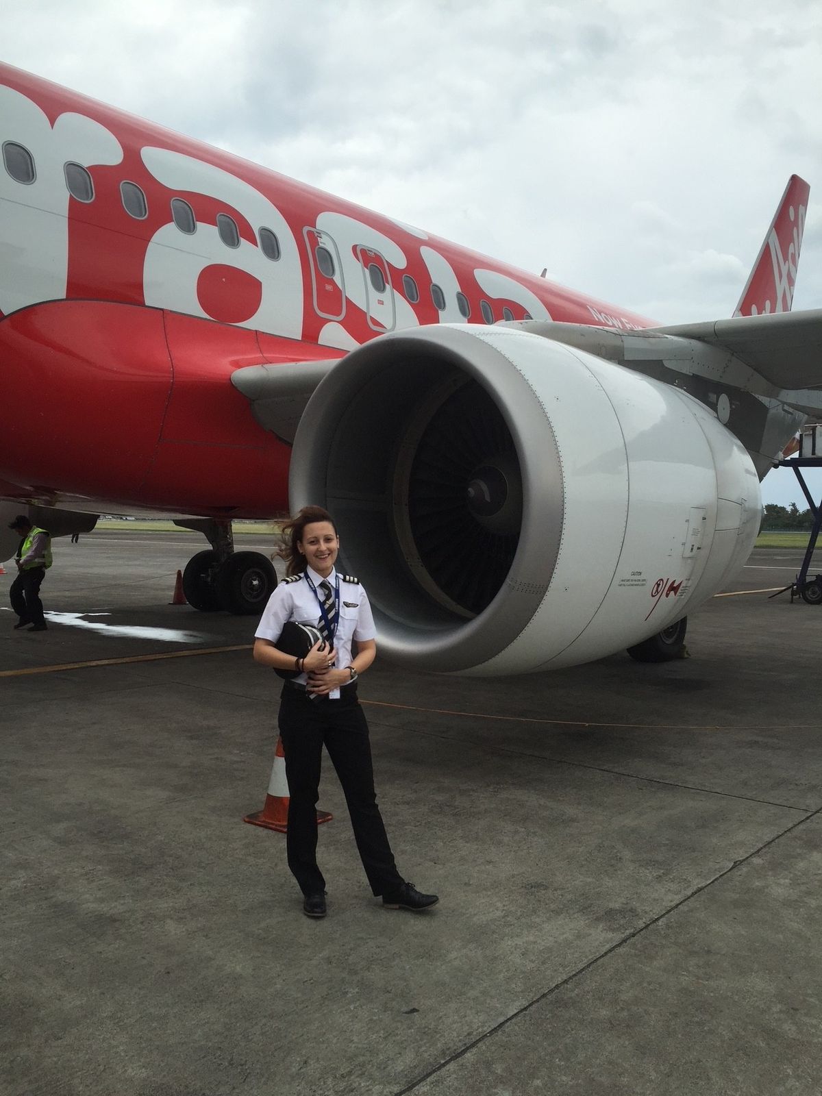 Malatinszky Anita női pilóta egy repülő mellett állva