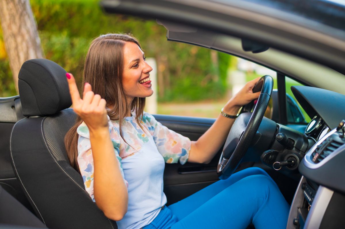 Egy fiatal nő a kocsiban énekel, ami a férfiak szerint idegesítő női szokások közé tartozik.