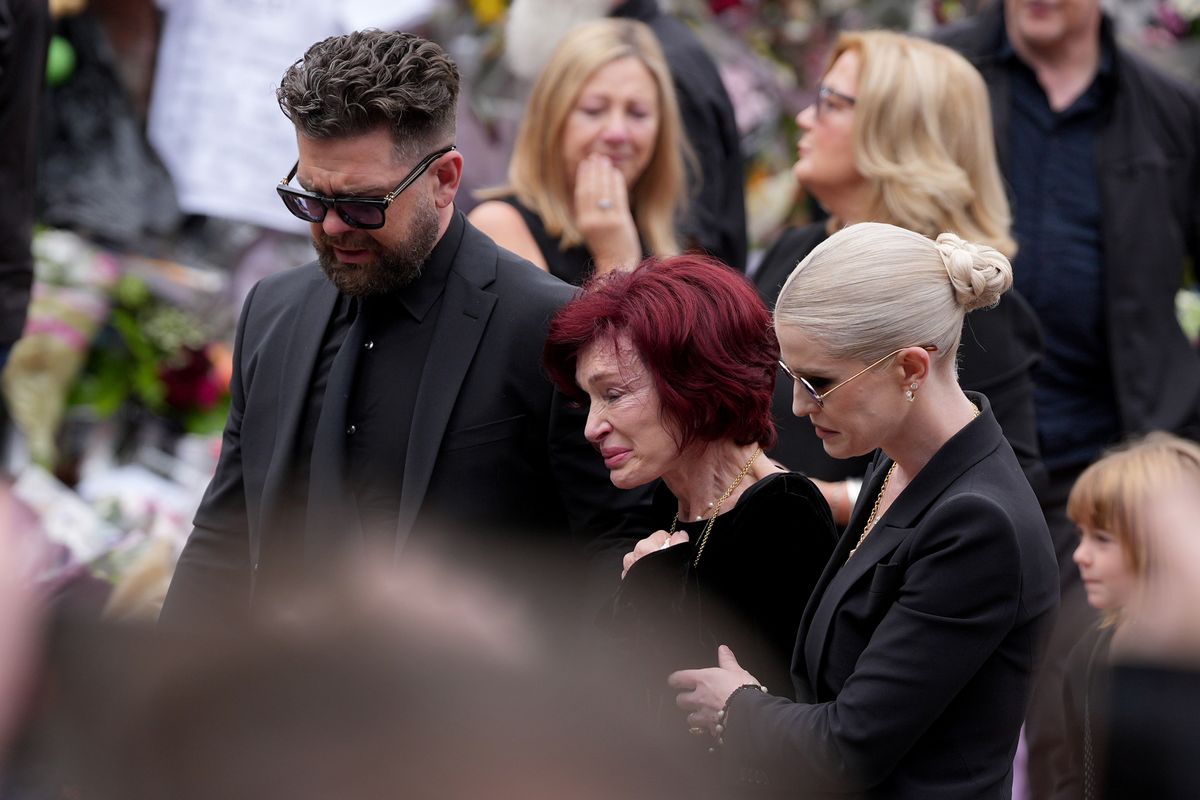 BIRMINGHAM, ENGLAND - JULY 30: Jack Osbourne, Sharon Osbourne, Kelly Osbourne and family members stop to view tributes to the late Ozzy Osbourne from fans at Black Sabbath Bench and Bridge as his funeral cortege travels through his home city of Birmingham on July 30, 2025 in Birmingham, England. The Black Sabbath frontman passed away on July 22nd at the age of 76. His death occurred just a little over two weeks after his final live performance at the 'Back to the Beginning' concert in his hometown of Birmingham.  (Photo by Christopher Furlong/Getty Images)