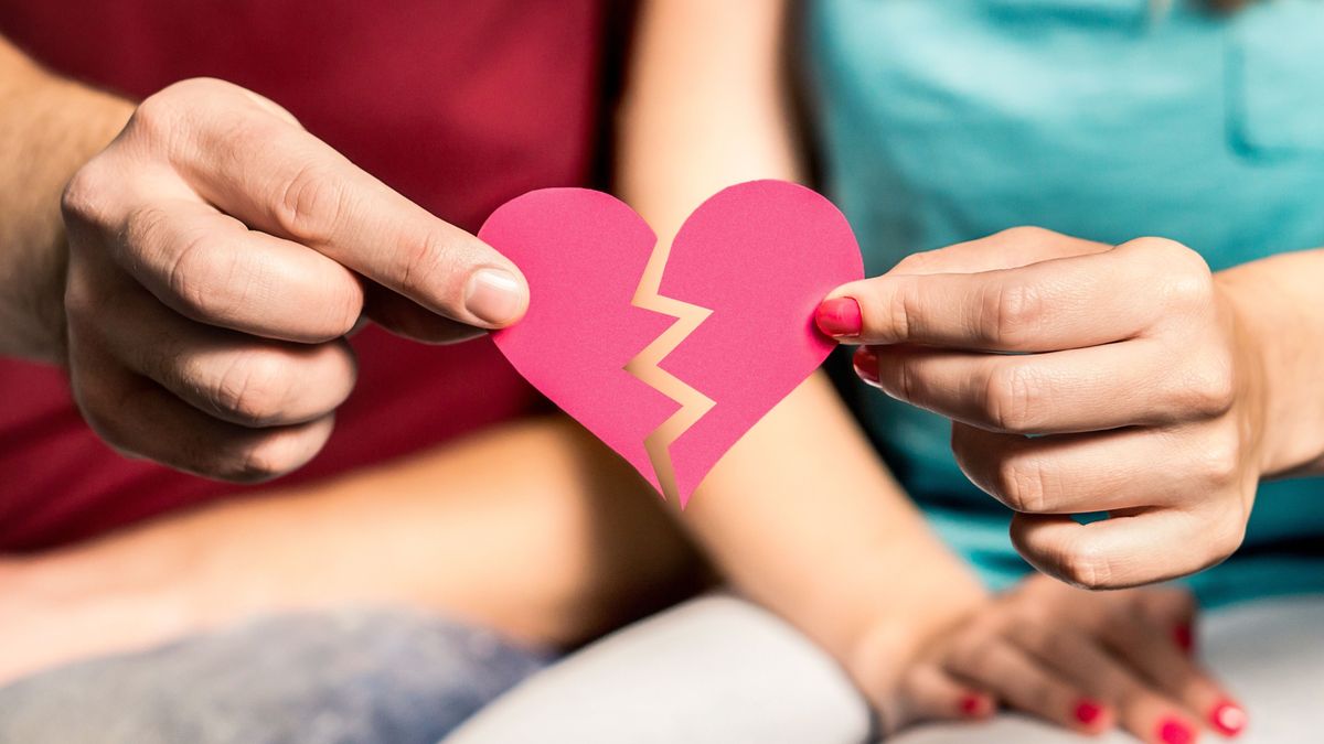 Törött szív egy pár ezében, ami a szakítást szimbolizálja.