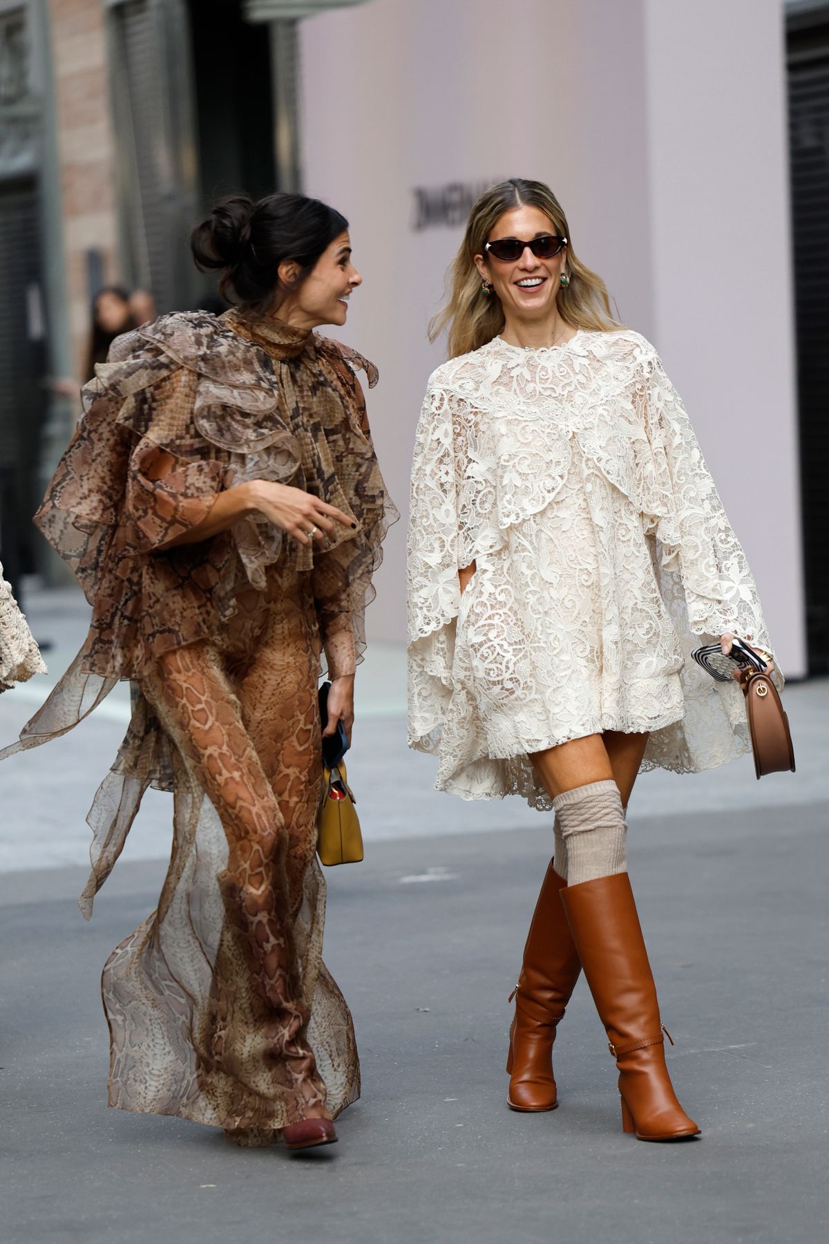 PARIS, FRANCE - OCTOBER 06: Guests wears snake skin pattern maxi dress with ruffles details (L), and cream lace long sleeves mini dress, beige socks and brown leather boots (R), outside Zimmermann, during the Womenswear Spring Summer 2026 as part of Paris Fashion Week on October 06, 2025 in Paris, France. (Photo by Claudio Lavenia/Getty Images)