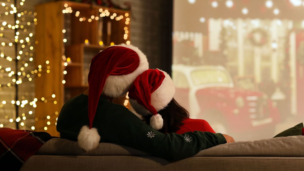 karácsonyi filmeket néző pár mikulás sapkában
